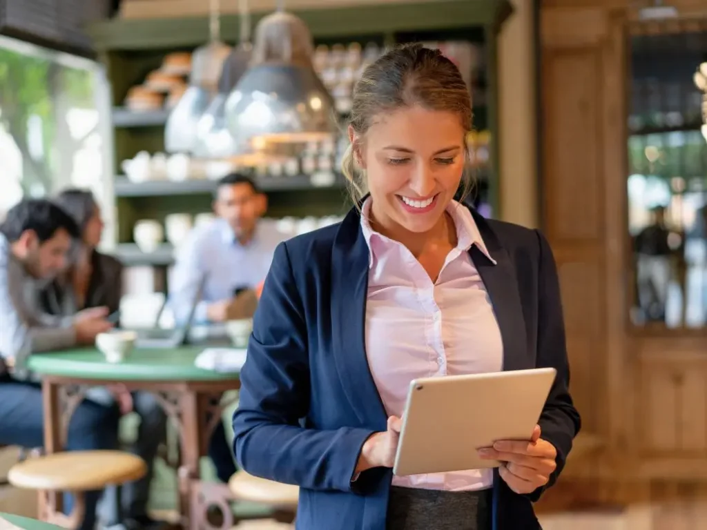Consultora de Bajo el Mantel OS revisando el panel de gestión basada en evidencia y reportes de un restaurante en una tablet.